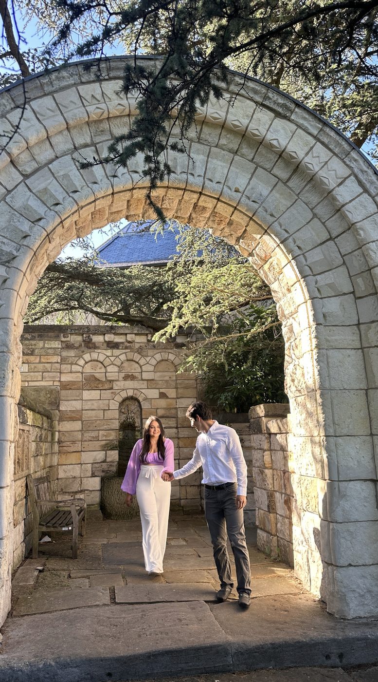 Walking hand in hand beneath a stone arch